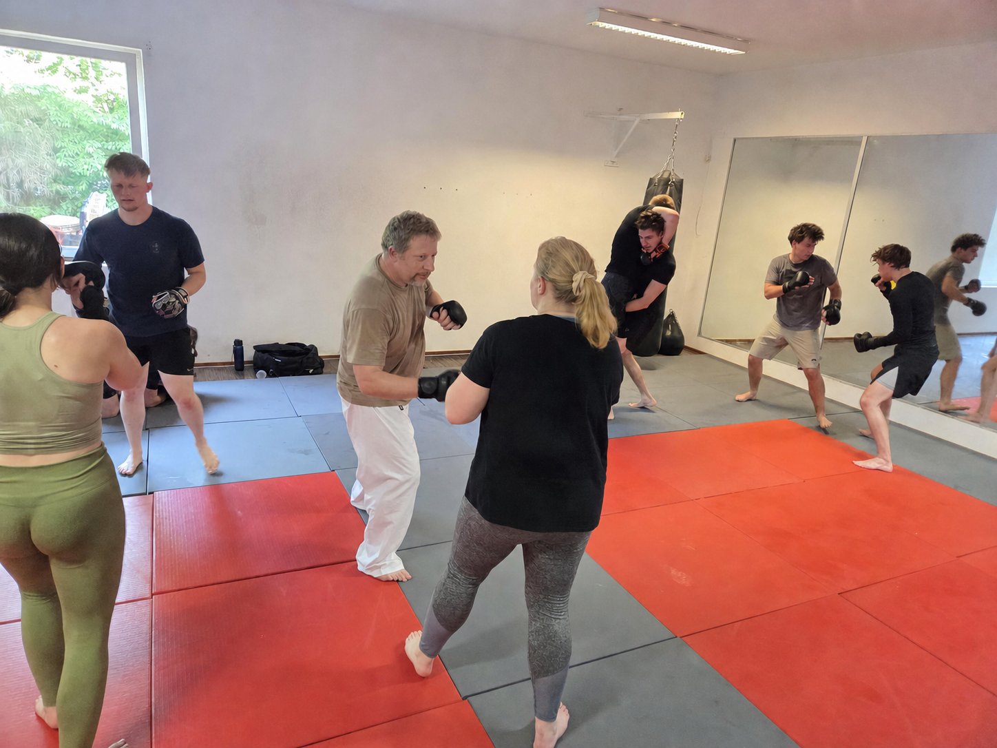 Frauen und Männer beim kontrollierten MMA-Training im Raccoons Gym